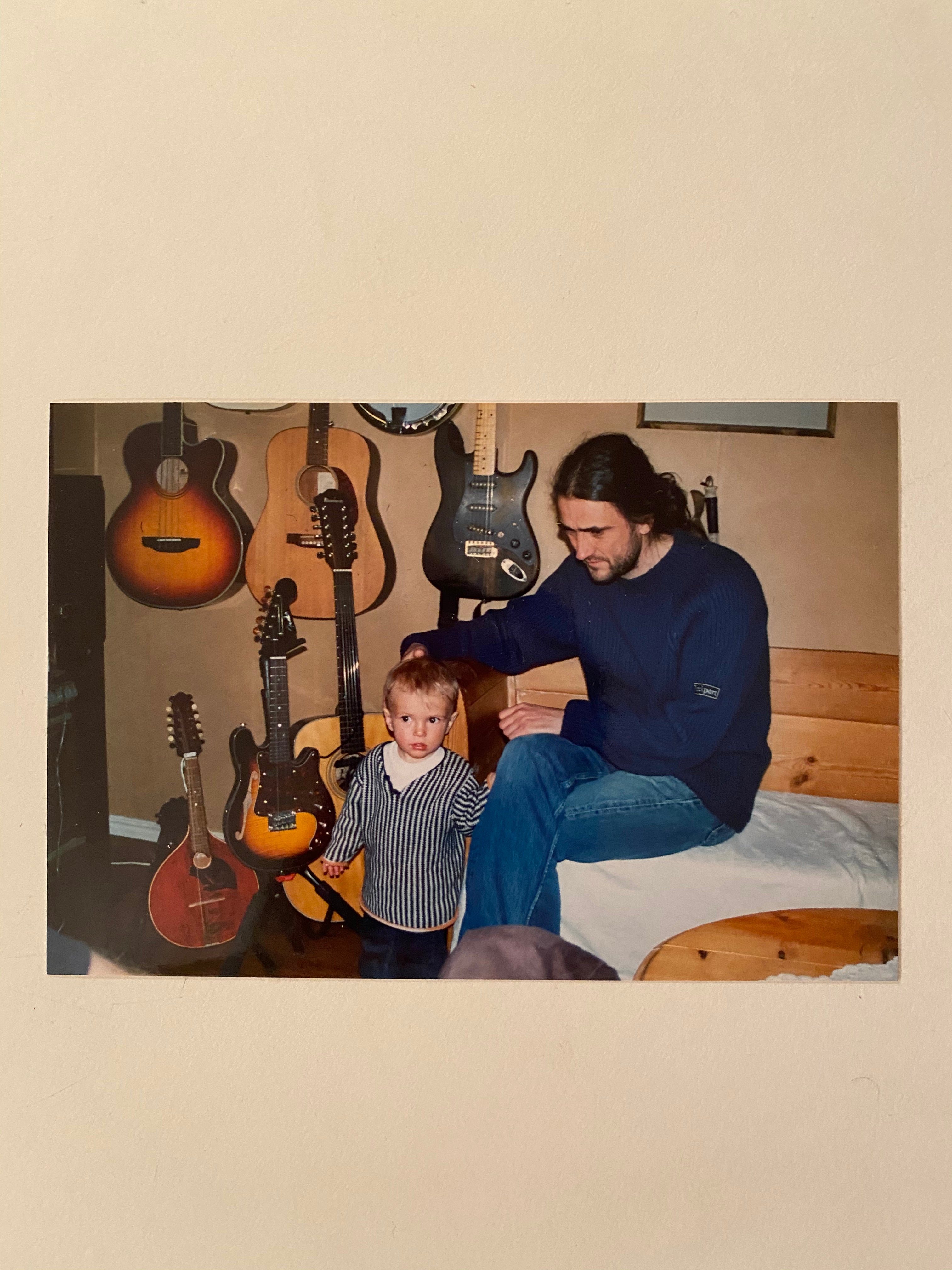 Man and child with guitars in a room